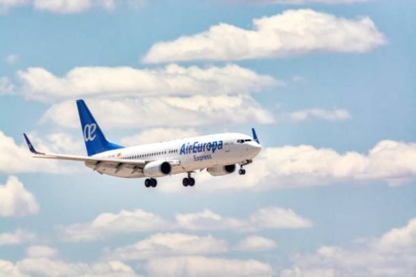 Madrid, Spain; 05-18-2024: Commercial airplane of the Boeing 737 model of the Spanish company Air Europa preparing to land by putting on the landing gear on a clear and cloudy day